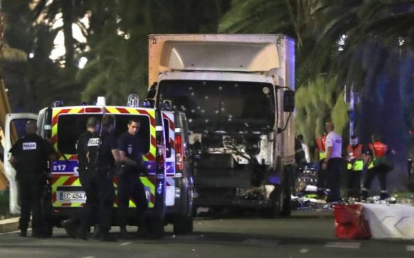 A devastated parent sits beside the body of a child run over by a semi-trailer driven by a crazed Islamic in Nice